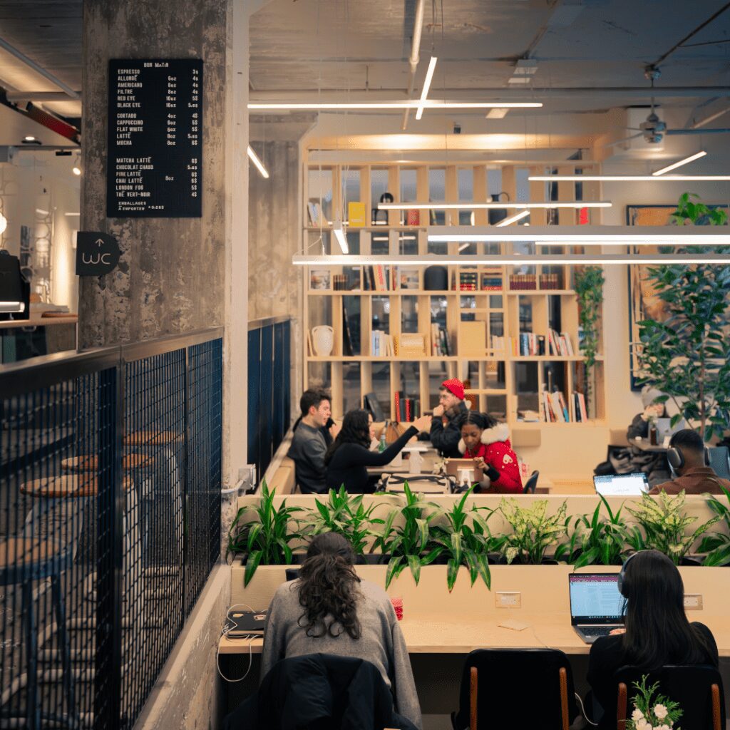 Vue intérieure du Café Paper Hill montrant des clients assis dans un cadre chaleureux avec des étagères remplies de livres.
