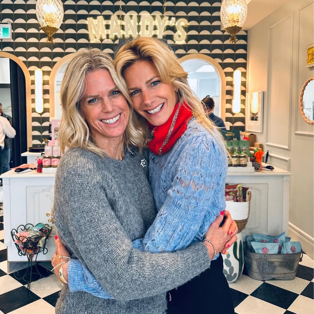 Les fondatrices de Mandy’s, souriantes et enlacées, devant leur enseigne emblématique au décor chic et chaleureux.