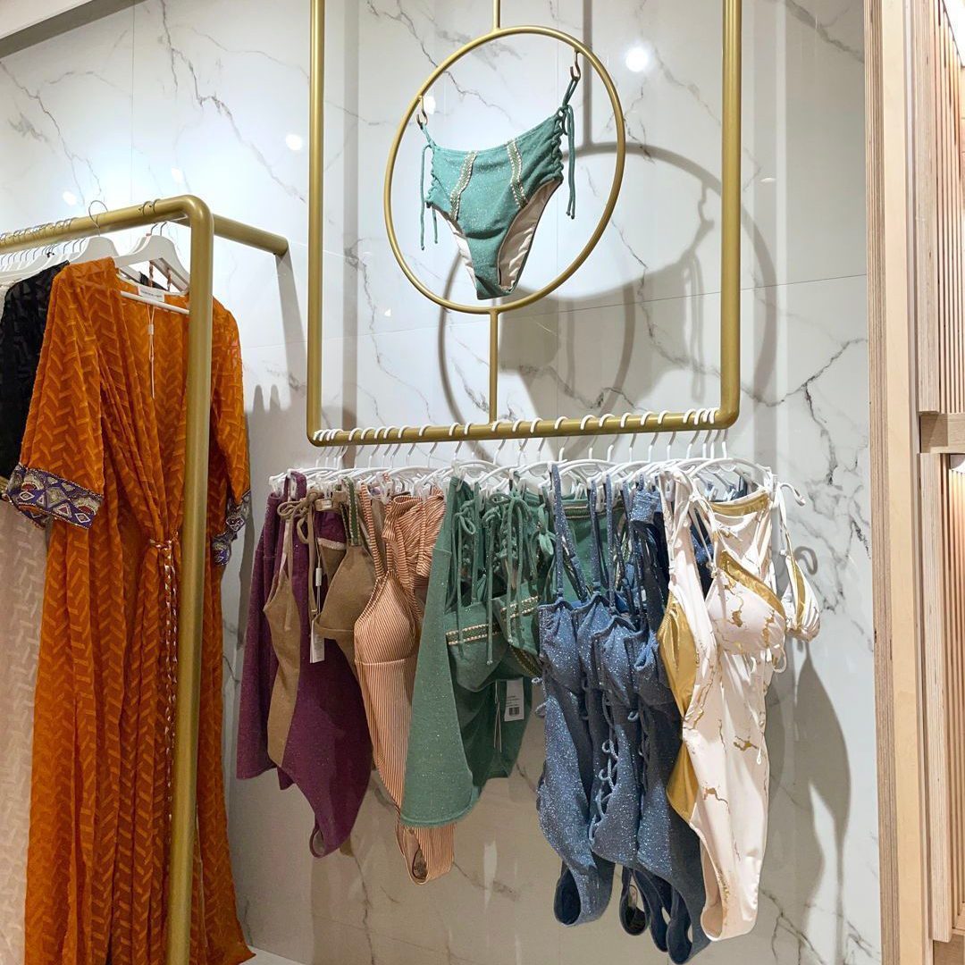Boutique élégante mettant en valeur des maillots de bain raffinés suspendus dans un présentoir doré.